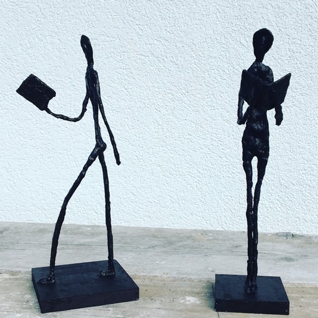 Zwei filigrane Giacometti-Figuren beim Lesen